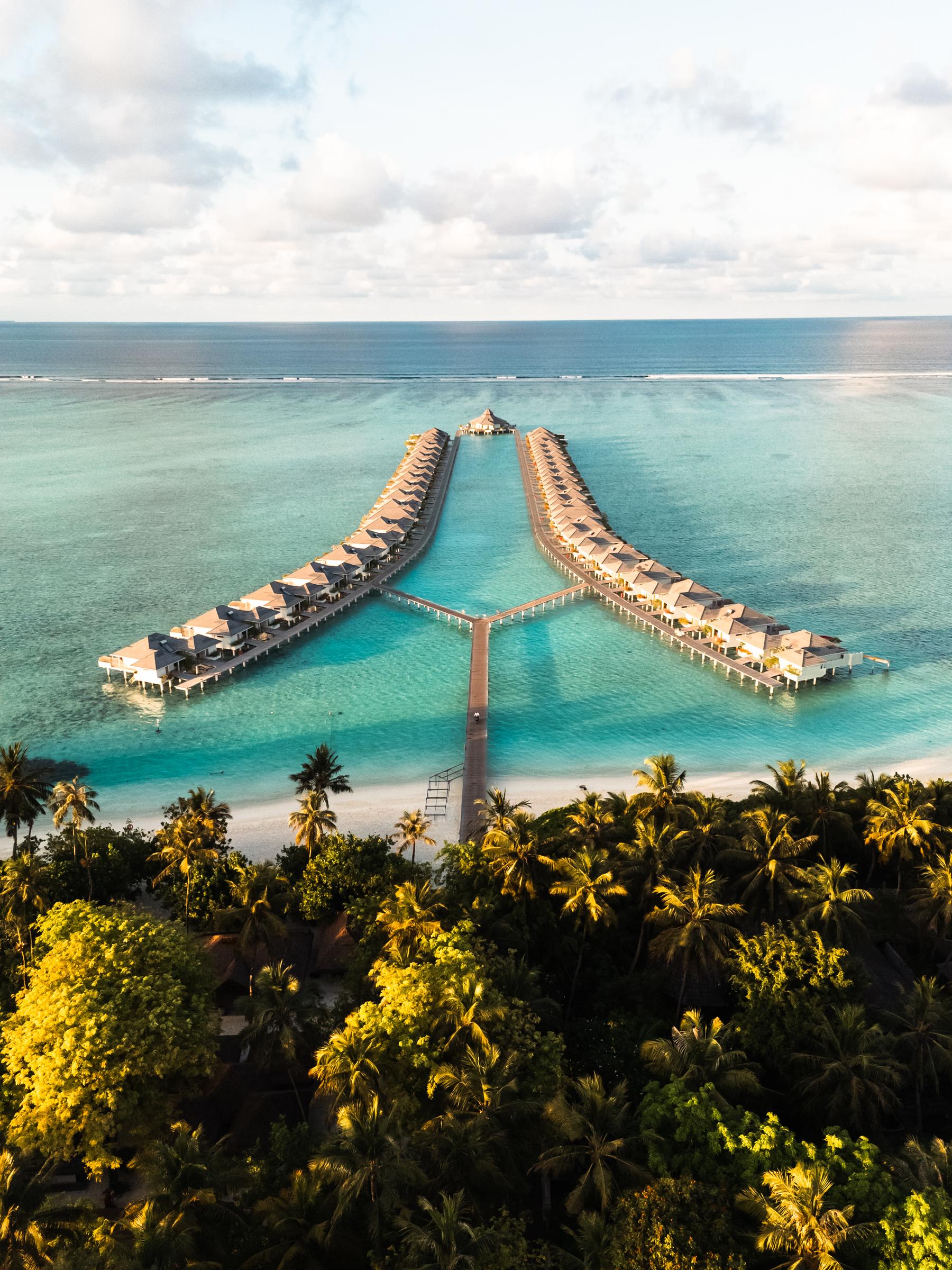 Aerial view of overwater villa jetties over a turquoise lagoon, Maldives