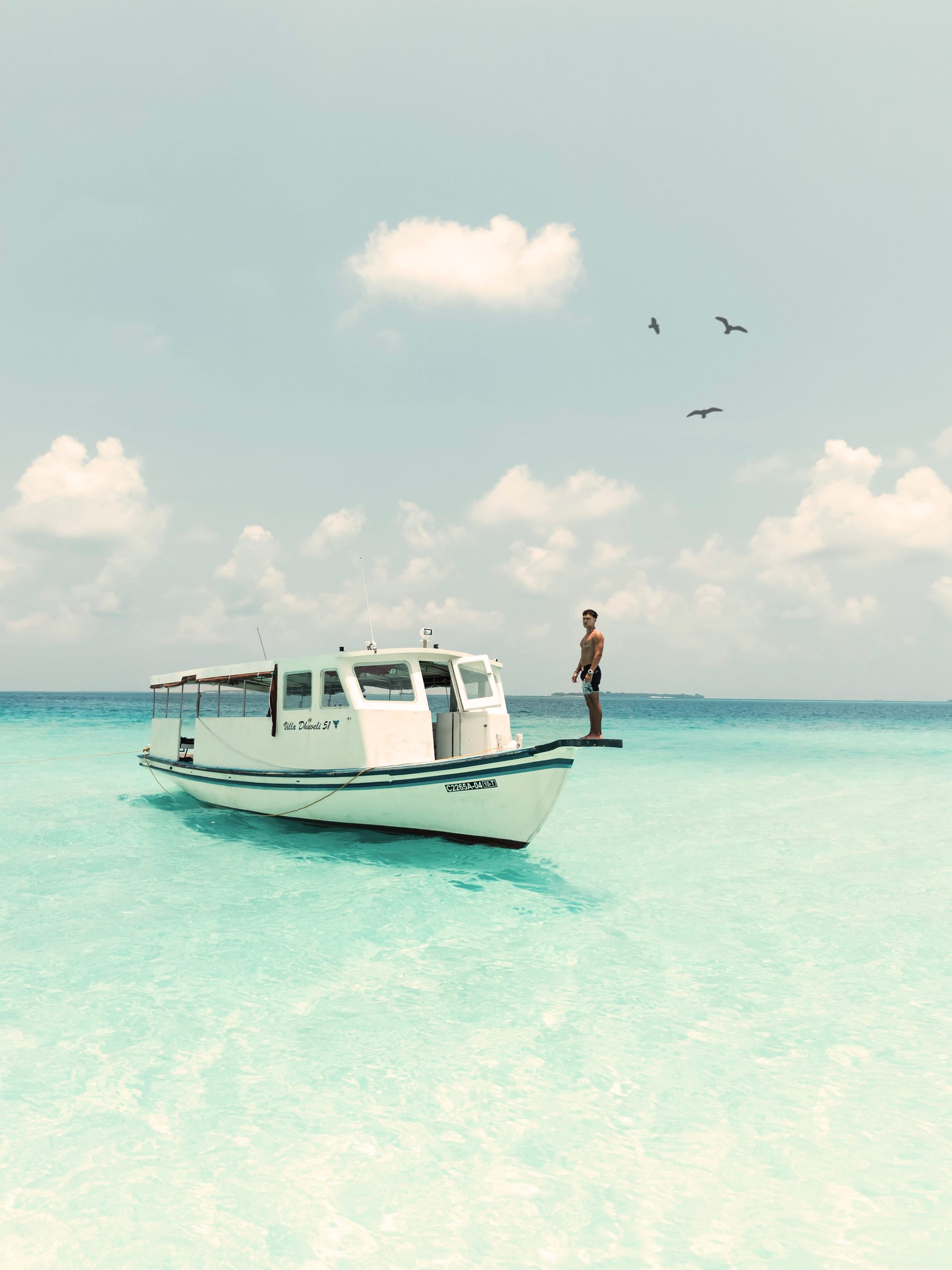 Boat anchored in a turquoise lagoon in the Maldives