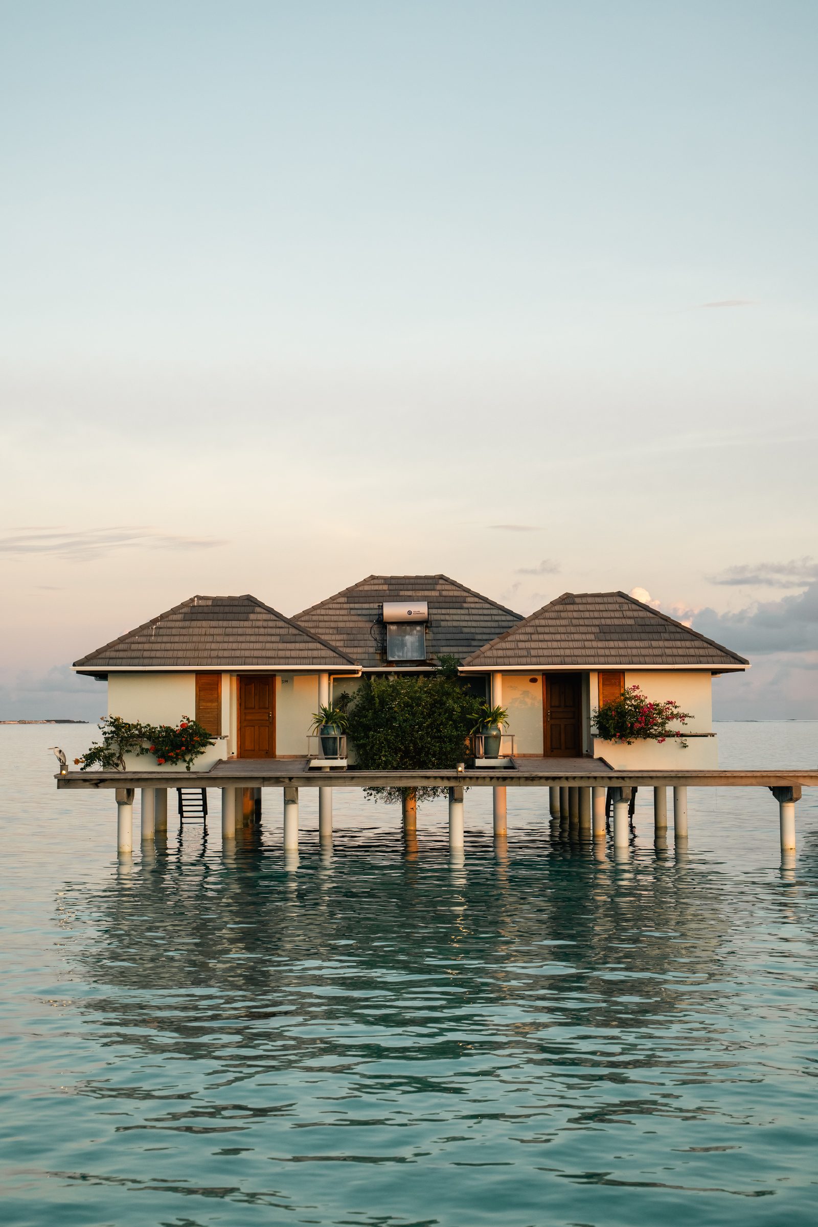 Overwater villa reflected in calm turquoise water, Maldives