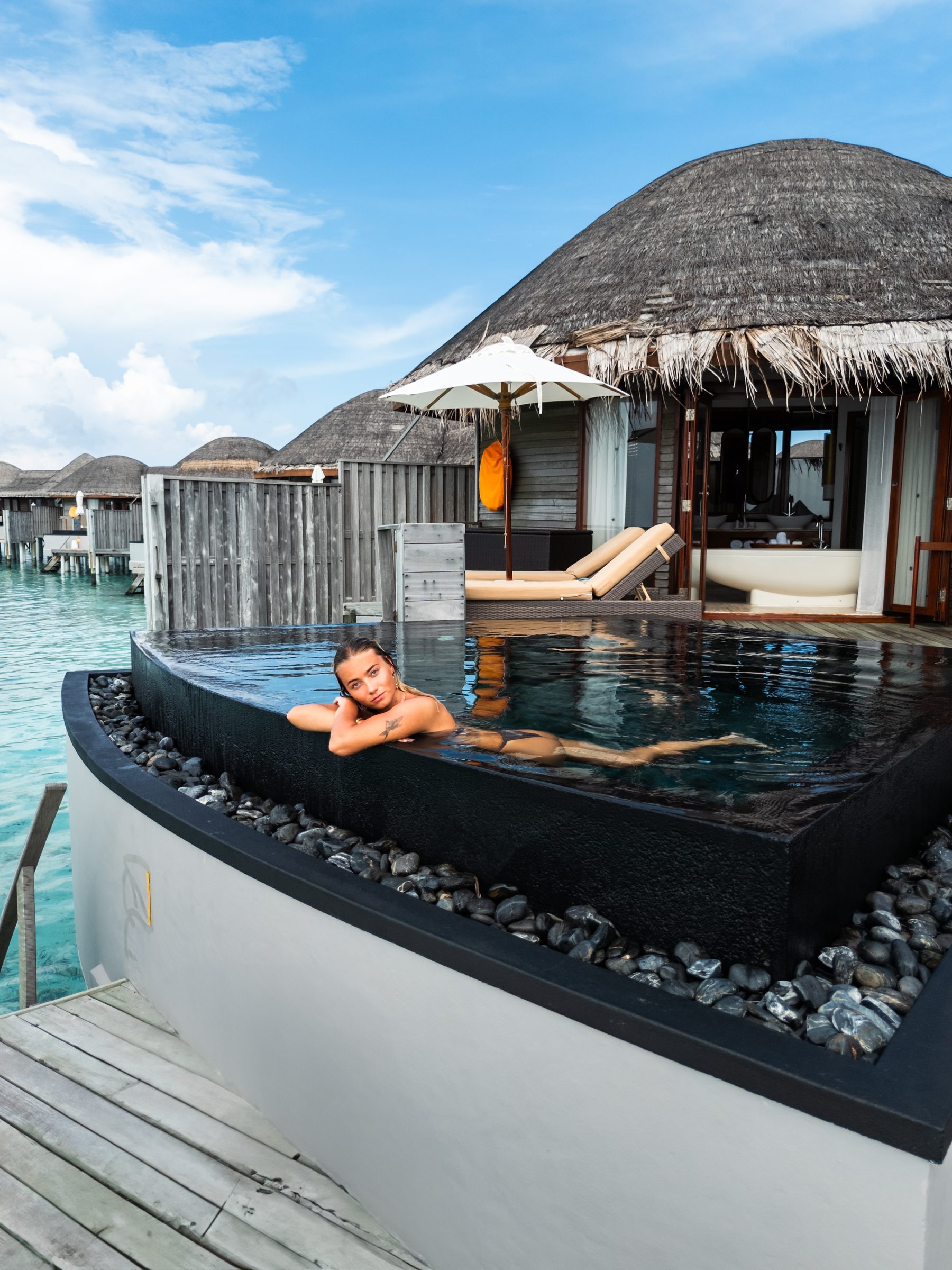 Guest relaxing in a private plunge pool of a water villa, Maldives