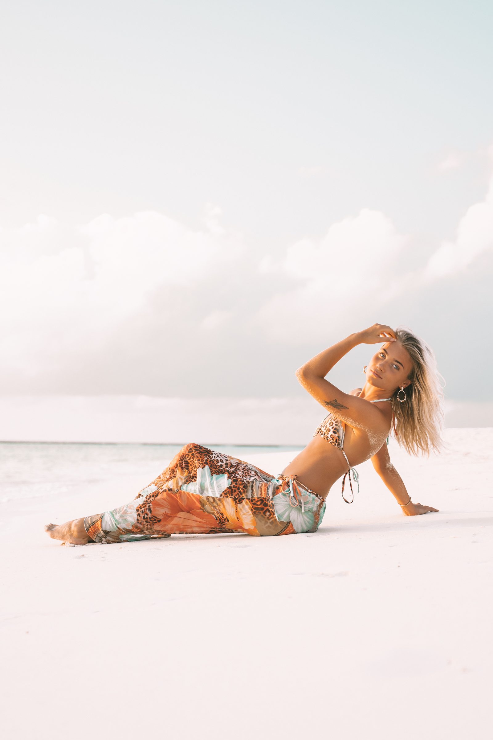 Woman posing on white sand in a light fashion shoot, Maldives